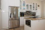 This beautiful granite kitchen island includes a downdraft glass-top electric stove, oven, and microwave